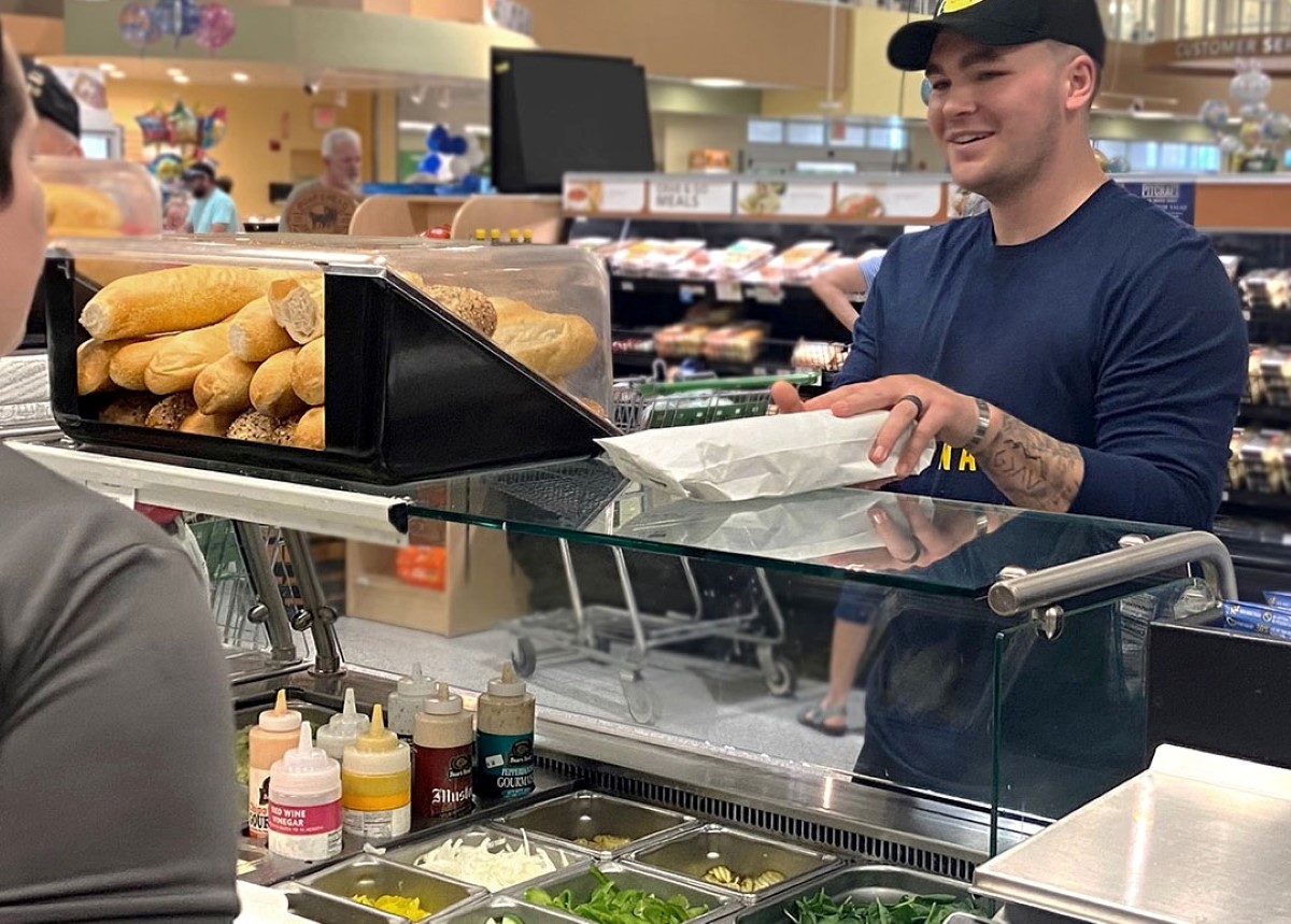 Customers interact with staff at supermarket