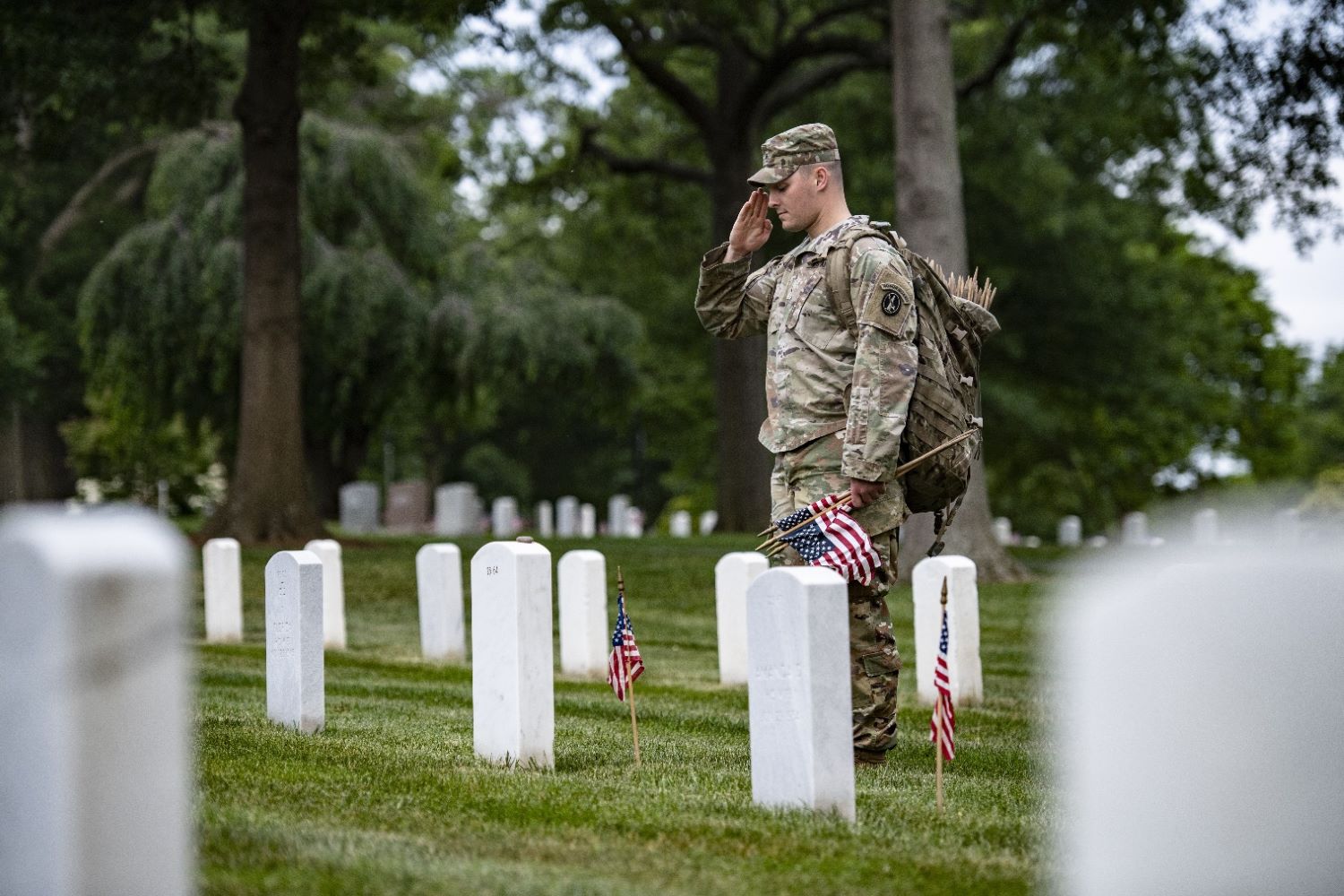 soldiers honored fallen service members by placing American flags at gravesites