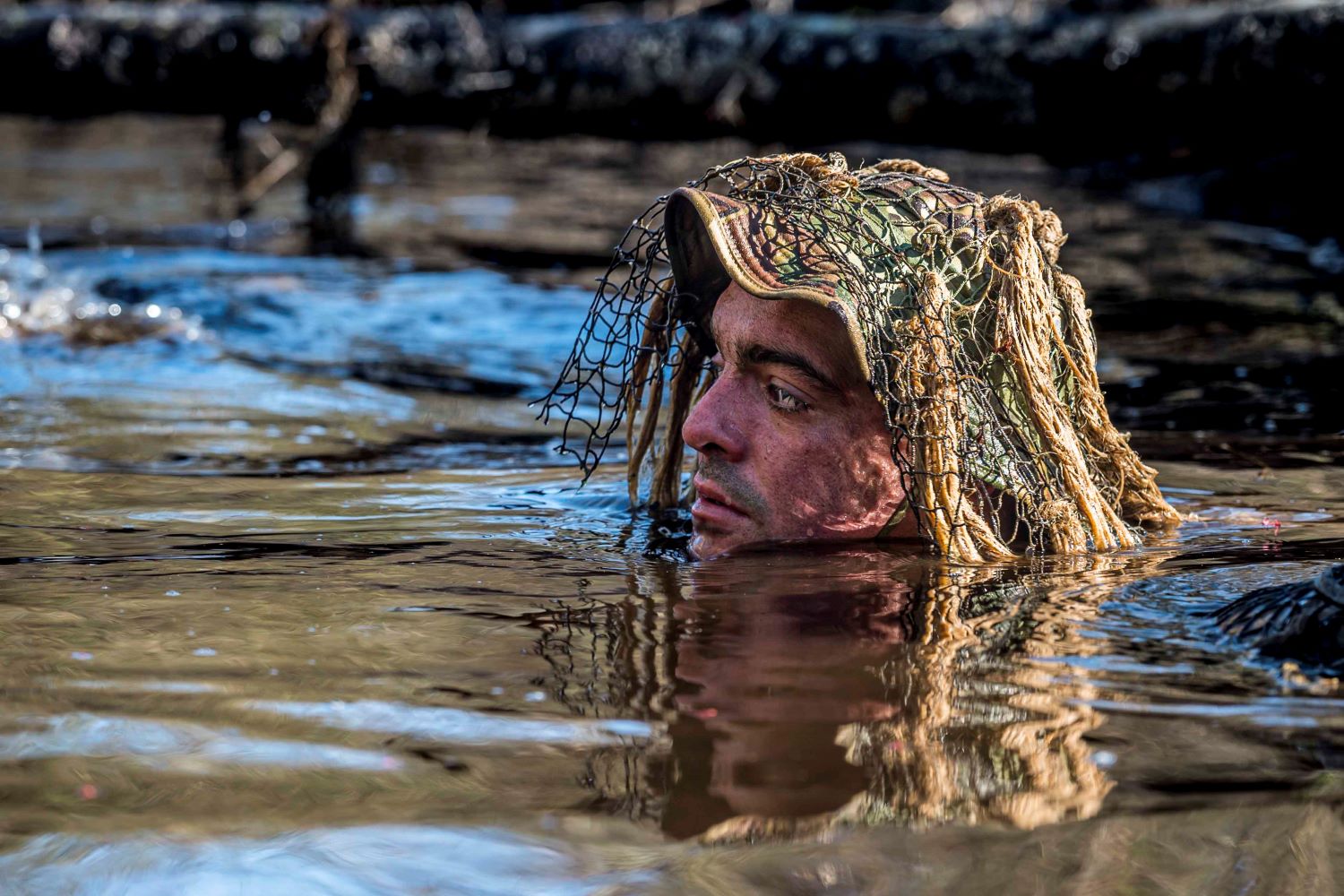 A soldier is seen participating in a ghillie wash