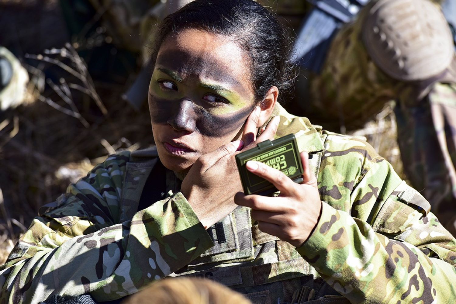 U.S. Army Capt. Julissa Myers meticulously applies the finishing touches to her face paint camouflage