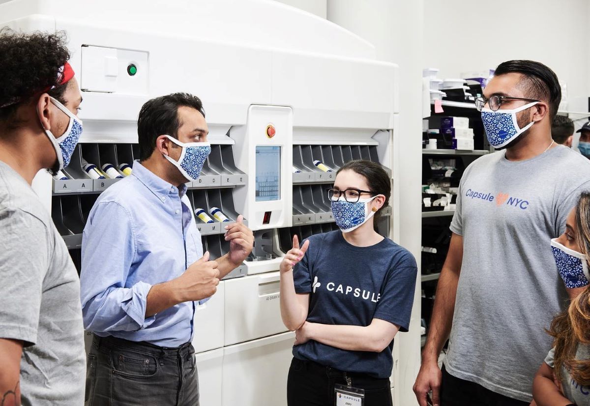 Capsule CEO and founder collaborate with staff at distribution store