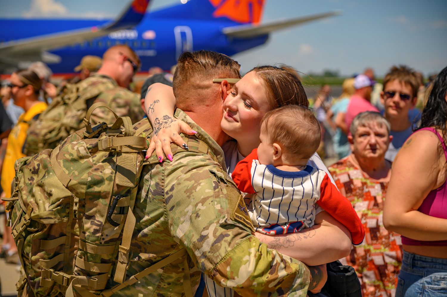 a soldier is holding his family close
