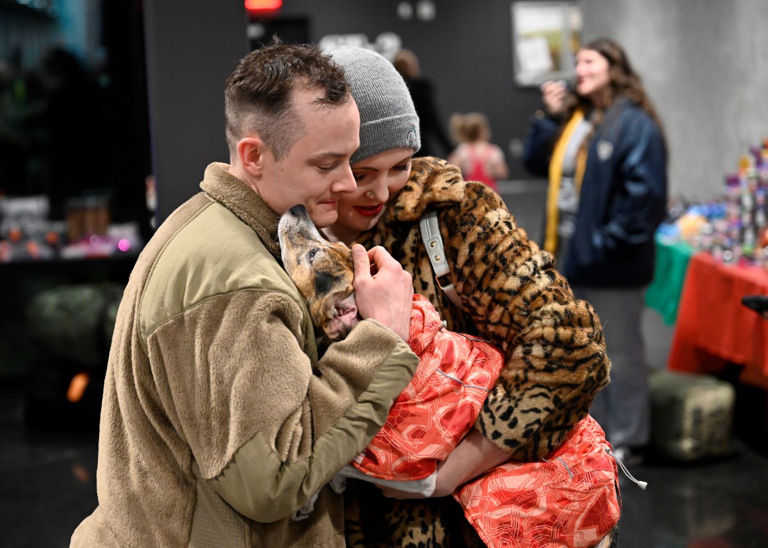 a soldier holds his wife and their dog