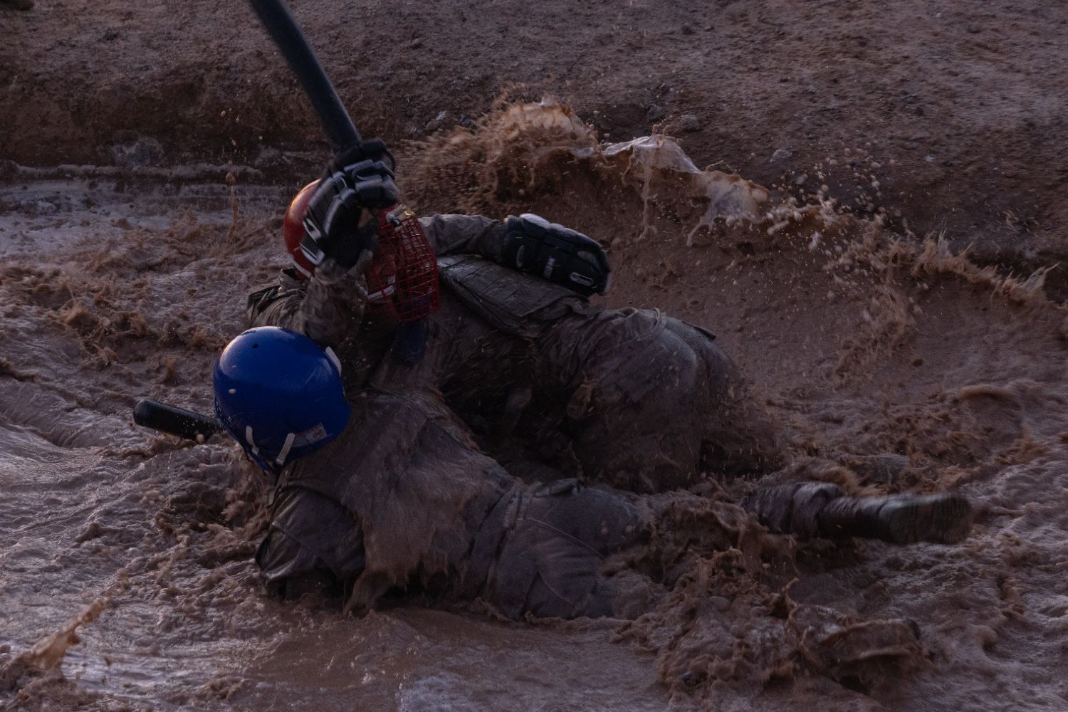 two soldiers spar in the mud and water