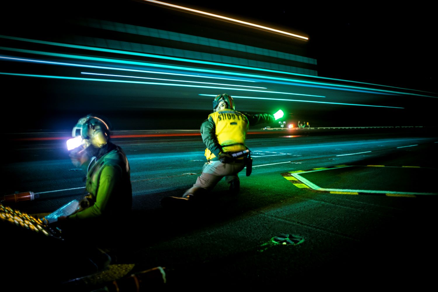 Lt. Elliot Reed signals a Carrier Air Wing 8 F/A-18E Super Hornet for launch