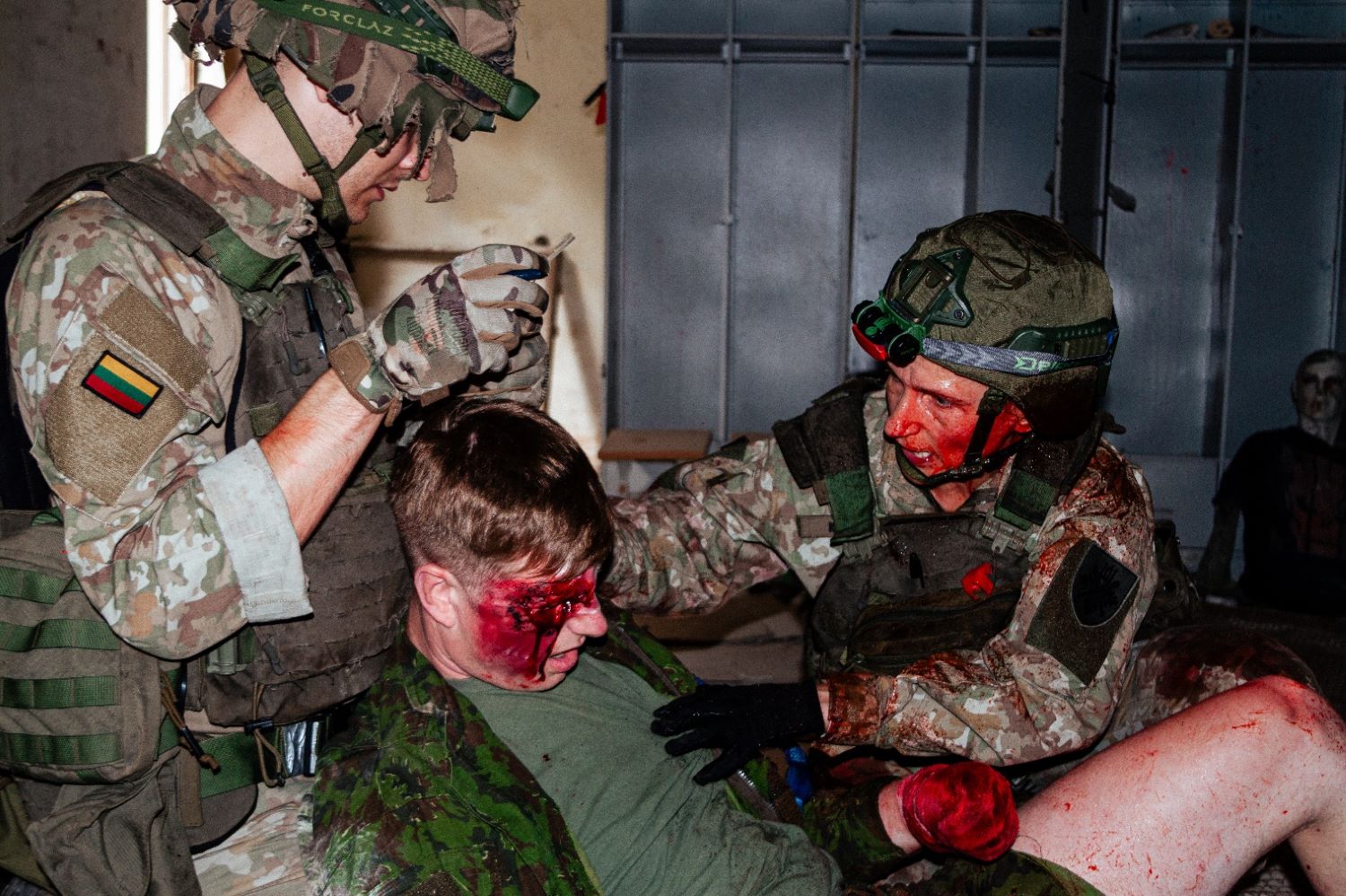 Lithuanian National Guard members assess a simulated injury during Tactical Combat Casualty Care (TCCC) training